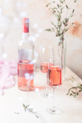 Fototapeta na wymiar Two glasses and bottle of rose wine on light background.