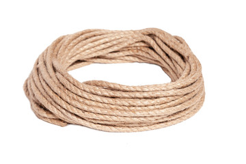 Closeup of rough brown braided rope coiled in the form of ring. Concept equipment, strength, sport,...