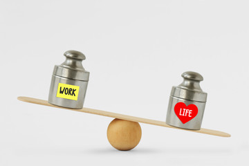Weights with the words Work and Life written on paper note on balance scale - Concept of life and...