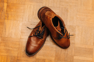 pair of old brown leather shoes on wooden background