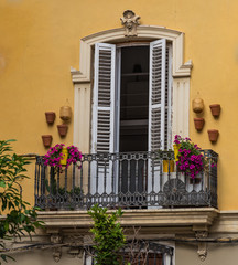 Fototapeta na wymiar Balcony decorated with flowers and pots with a door in Valencia, Spain