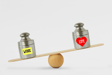 Weights with the words Work and Life written on paper note on balance scale - Concept of work...