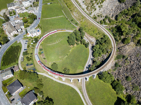 A train is going through the famous circular viaduct in Swiss Alps mountain, Brusio, Canton Grisons, This spiral viadukt is a unesco heritage. opened in 1908.