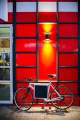 Bicycle against red wall. Space for text messages.