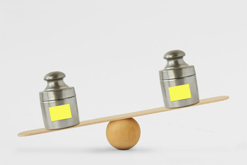 Weights with blank paper note on balance scale - Concept of imbalance