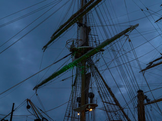 Masts and the rigging of ancient sailboat on nignt sky background. Exterior of old tall ship. Amerigo Vespucci - bow of ancient sailing vessel.