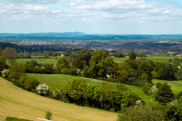 Fototapeta na wymiar Extensive views over the City of Gloucester in the Severn Vale with the Malvern Hills in the distance. From Cud Hill Common on the western edge of the Cotswolds, Gloucestershire, England, UK