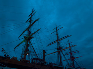 Masts and the rigging of ancient sailboat on nignt sky background. Exterior of old tall ship....