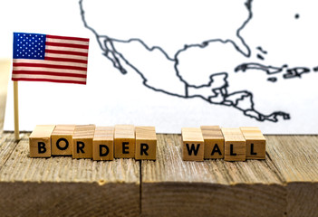 Border Wall USA concept with American flag on white background and wooden board