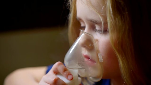 girl of nine years have asthma breathing inhaler for treatment of the disease