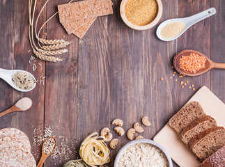 Flour, bread, dry pasta and lentils and other ingredients on the wooden table.