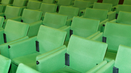 Conference hall o seminar room, rows of empty green seat in auditorium