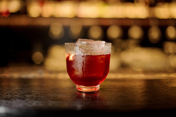 Glass of a Vieux Carre cocktail on the wooden bar counter