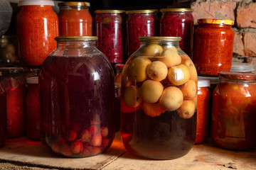 Canned vegetables in transparent glass jar. Apple compote in large transparent jars. Homemade canned juice