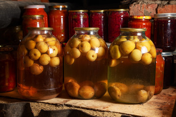 Canned vegetables in transparent glass jar. Apple compote in large transparent jars. Homemade canned juice