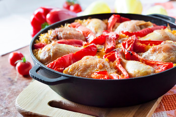 Chicken thighs and legs baked over a bed of rice and red bell pepper