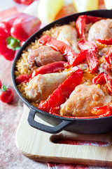 Chicken thighs and legs baked over a bed of rice and red bell pepper