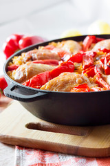 Chicken thighs and legs baked over a bed of rice and red bell pepper