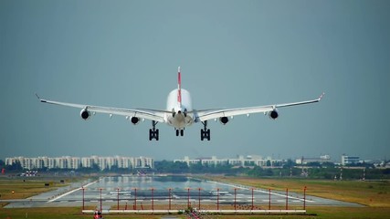 Commercial aeroplane or airliner on a final approaching landing at an International Airport on a clear morning sky