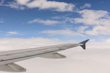 Aerial view of wing from jetplane blue sky and big white cloud background