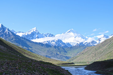 Fototapeta na wymiar Jammu-Kashmir landscape with snow peaks,green valley and blue cloudy sky in background in India