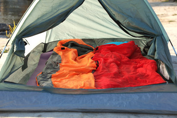 Camping tent with sleeping bags in wilderness