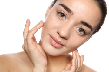 Portrait of young woman with liquid foundation on her face against white background