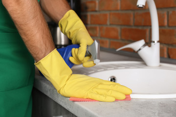 Man cleaning kitchen sink with rag, closeup