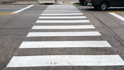 crosswalk on the road for safety when the car has passed the white crosswalk sign in the morning