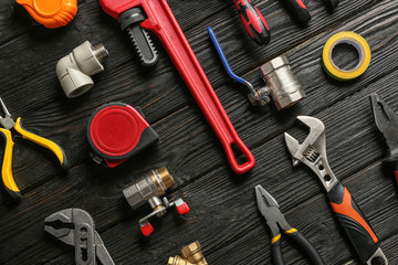 Flat lay composition with plumber's tools on wooden background