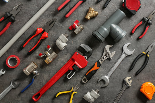 Flat lay composition with plumber's tools on grey background