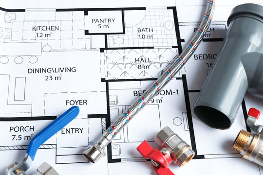 Professional plumber's supplies on house plan, closeup