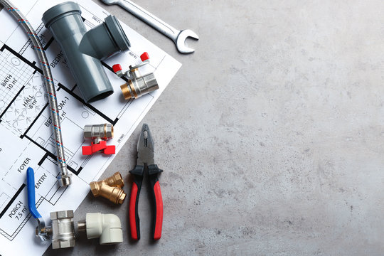 Flat lay composition with plumber's tools and space for text on grey background