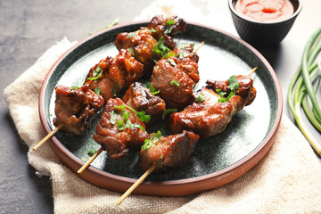 Plate with delicious meat served for barbecue party on gray table