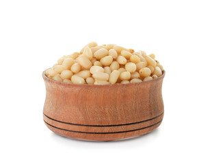 Bowl with pine nuts on white background