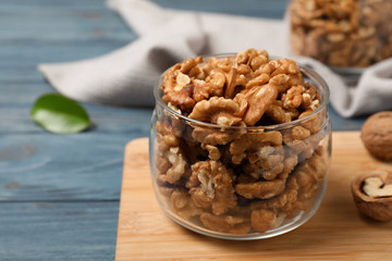 Tasty walnuts in glass jar on table