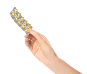 Woman holding pills in blister pack on white background, closeup