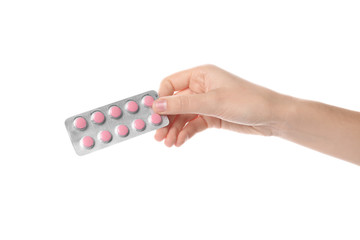 Woman holding pills in blister pack on white background, closeup