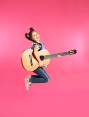Cute little girl playing guitar on color background