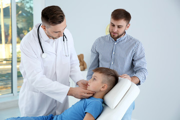 Father and son visiting pediatrician. Doctor working with patient in hospital
