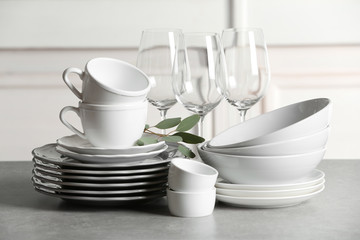 Set of clean dishes on table against blurred background