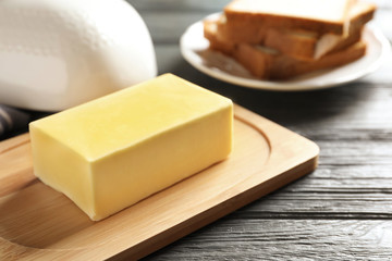 Wooden board with fresh butter on wooden table