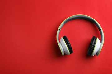 Wireless headphones on color background, top view. Space for text