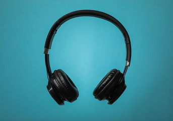 Wireless headphones with earmuffs on color background