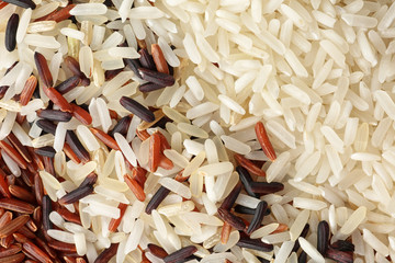 Brown and other types of rice as background, closeup