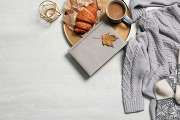 Flat lay composition with warm sweater and space for text on light background