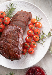 Roast beef sliced with cherry tomatoes and berry sauce