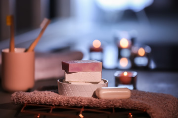 Soap bars and towel on table against blurred background. Space for text