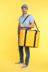 Young courier with thermo bag on color background. Food delivery service