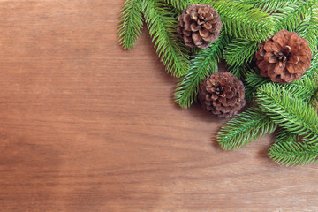 Christmas background. Fir tree branches and pine cones with decoration on a wooden board. with copy space for text.